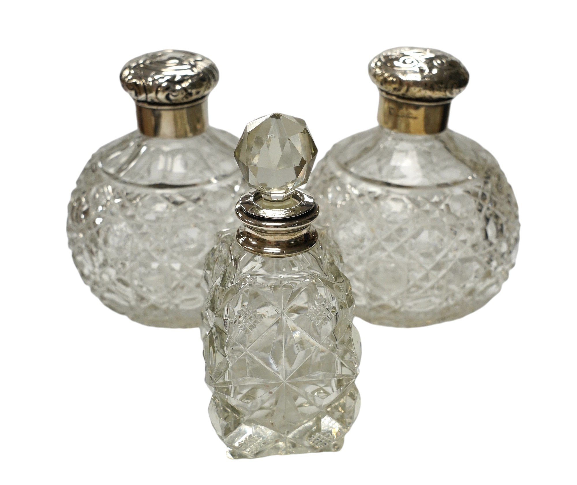 A pair of silver mounted cut glass scent bottles, marks rubbed, 12.3cm and one other silver mounted scent bottle. Condition - poor